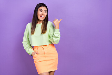 Wall Mural - Photo of dreamy excited girl dressed green sweatshirt showing thumb looking empty space isolated violet color background