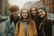 © acrogame - Teenager girls and a boy in town looking together at the camera and smiling