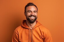 Smiling Man In Orange Hoodie Looking At Camera Isolated On Orange