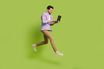 Aufkleber - Photo of cheerful funny man dressed striped shirt holding laptop typing email hurry running shopping isolated on green color background