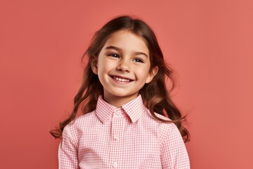 Wall Mural - Cheerful little girl looking at camera and smiling isolated over pink background