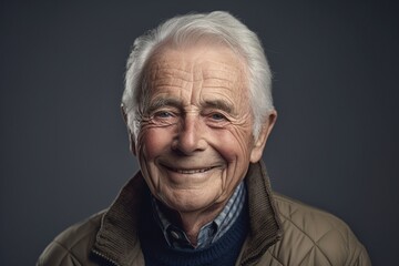 Senior self confident and happy man portrait in his 70s, with an easy smile, neutral background