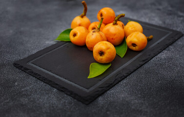 Wall Mural - Loquat Medlar fruit isolated on dark table background