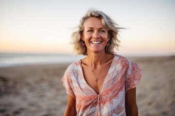 Wall Mural - Portrait of smiling woman standing on beach at sunset in the sunshine