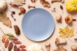 © Alina - Empty plate with pumkins, mushrooms and autumn leaves on beige background top view. Monochrome autumn flat lay