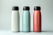 Mockup of three stainless steel tumbler bottles with different colour variations. white background.