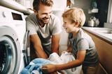 The son helps his father load dirty laundry into washing clothes