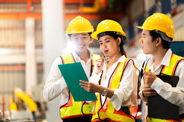 two professional engineer,worker,technician use clipboard discuss work, walk in steel metal manufacture factory plant industry. Black African American man and woman wear hard hat check quality machine