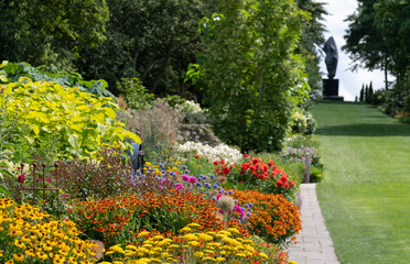 Stunning, colourful mixed flower borders at RHS Wisley Garden, Surrey UK. The extensive flower beds have mainly perennial plants growing in them.