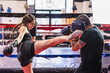 © Sangiao_Photography - Sparring self-defense K1 Kickboxing Hispanic young sportswoman with mature fitness trainer in gym