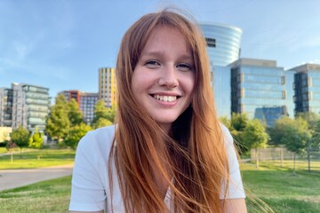 Wall Mural - portrait of a young girl on the background of the business center in summer weather