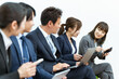 © buritora - 会社でパソコン・スマホ・タブレットを使うスーツ姿の会社員（アジア人・男女・5人）