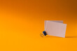 White business cards with paperclip and copy space on orange background