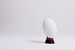 White rugby ball on red and black stand with copy space on white background