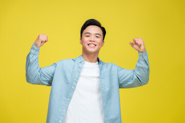 Wall Mural - Cheerful excited man standing isolated over yellow background, celebrating success