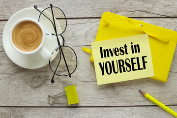 yellow notepad cup of coffee. words on sapis invest in yourself