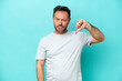 © luismolinero - Middle age caucasian man isolated on blue background showing thumb down with negative expression