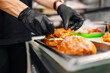 © pavel siamionov - chef hand cooking cheeseburger with vegetables and meat on restaurant kitchen