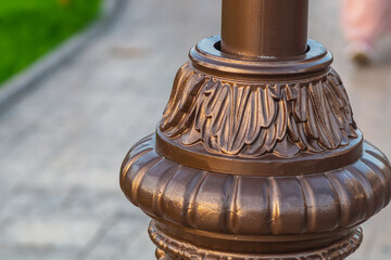 The lower part of the street lighting stalk made of forged artistic elements for decorating parks or other public places. The use of blacksmith products in everyday life