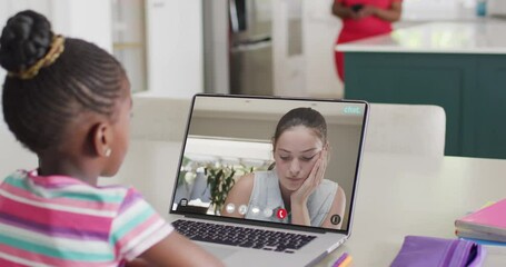 Sticker - Diverse schoolgirl having laptop video call with female student in slow motion