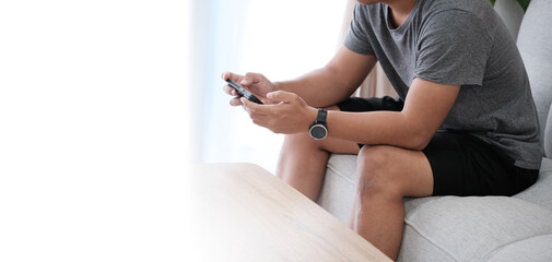 man use smartphone at home , chatting or shopping online, looking at phone screen, browsing mobile device apps , iphone