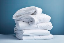 A Stack Of White Bedding On A Blue Background.