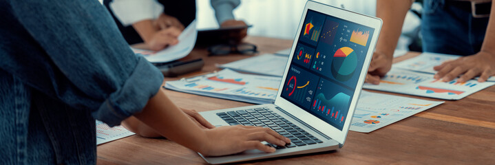 Fototapete - Panorama shot analyst team utilizing BI Fintech to analyze financial report with laptop. Businesspeople analyzing BI power dashboard displayed on laptop screen for business insight. Scrutinize
