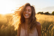 canvas print picture - Young happy smiling woman standing in a field with sun shining through her hair