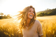 © MVProductions - Young happy smiling woman standing in a field with sun shining through her hair