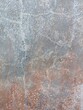 Funky gray concrete wall with irregular white chalk lines, faded wash of pastel pink and random spatters of dusty white all over abstract vertical background texture