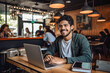 © MVProductions - Portrait of a Hispanic man working on a laptop computer in a busy cafe