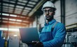 © amankris99 - Confident engineer in blue jumpsuit holding laptop computer in a warehouse, Generative AI