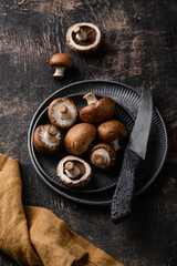 Raw champignon mushrooms on black background