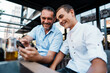 © Dusko - Handsome and happy father and his teenager son sitting in a restaurant and talking.
