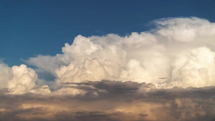 Wall Mural - close up time lapse of massive bright white cumulus clouds billowing upwards lit up by the sun and m