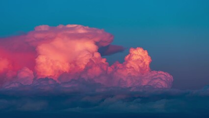 Wall Mural - close up time lapse of bright pink cumulonimbus storm clouds billowing up at sunset isolated on a bl