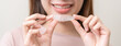Dental invisible braces, beautiful smiling asian young woman holding invisalign braces, wearing orthodontic silicone trainer, white smile using invisible whitening tray. Stomatology, dental healthcare