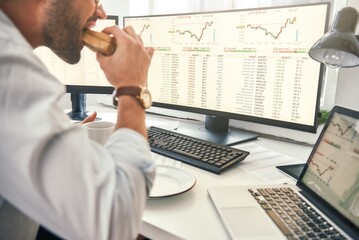 Fototapete - enjoying lunch. close-up of bearded trader is eating fresh sandwich and looking at monitor screen wi