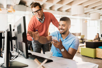 Young men working in a startup company office on a project