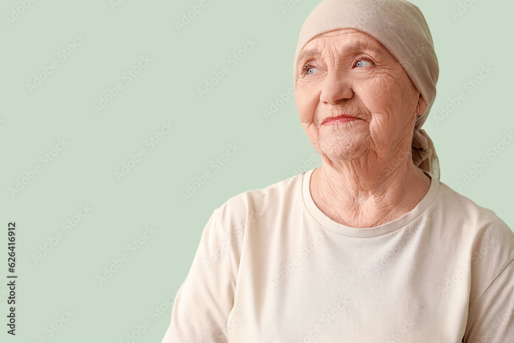 Senior woman after chemotherapy on green background
