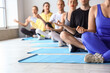 © Pixel-Shot - Group of sporty young people meditating in gym, closeup