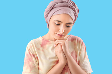 Wall Mural - Young woman after chemotherapy on blue background, closeup