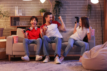 Poster - Father with his little children playing video game at home in evening
