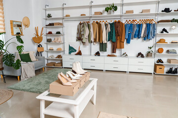 Wall Mural - Stylish clothes with shoes and accessories in light boutique
