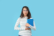 © Pixel-Shot - Asian Literature teacher with books on blue background