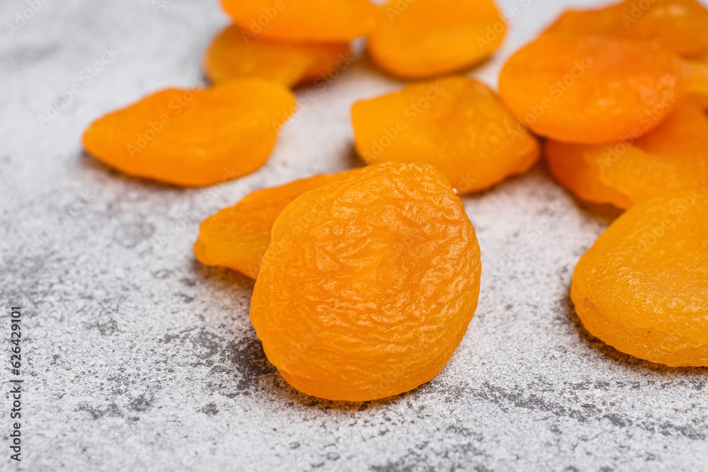 Tasty dried apricots on grey background