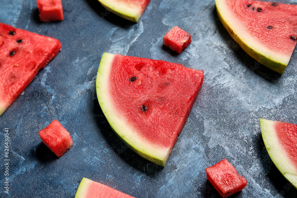 Composition with different pieces of ripe watermelon on blue background, closeup
