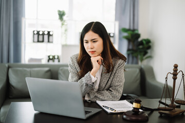 Asian lawyer woman working with a laptop and tablet in a law office. Legal and legal service concept.