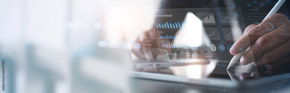 Businessman using digital tablet analyzing sales data and financial ...