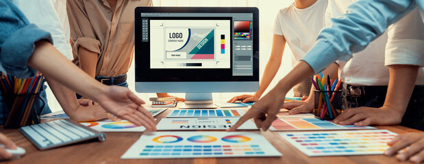 Leinwandbilder - Graphic designer brainstorming logo and graphic art at busy artistic workshop, laptop display workspace. Experimenting color palette and pattern for creative design. Panorama shot. Scrutinize